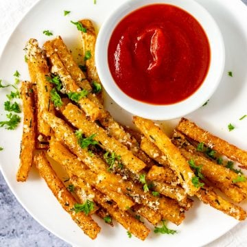 Square overhead photo of a plate of Keto Jicama Fries with a small dish of ketchup.