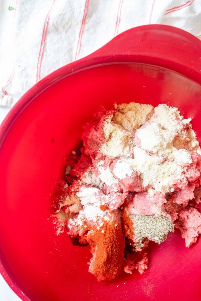 Photo of ground beef, almond flour, salt, paprika, onion powder, and garlic powder in a bowl