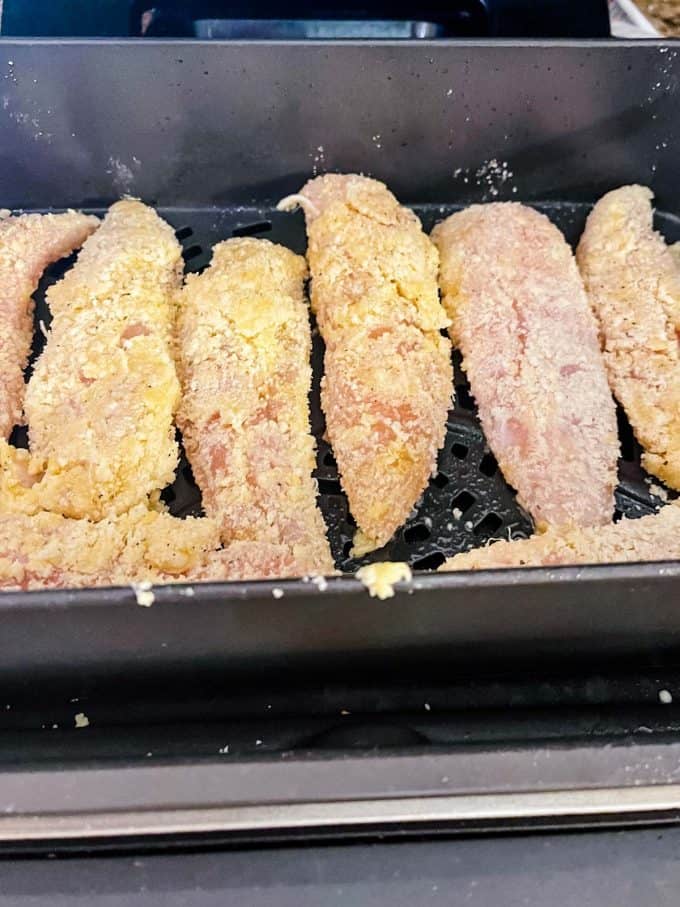 Photo of breaded chicken tenders in the ninja foodi grill.