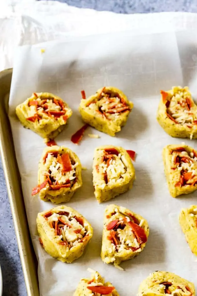 Photo of sliced pizza bites on a parchment lined baking sheet.