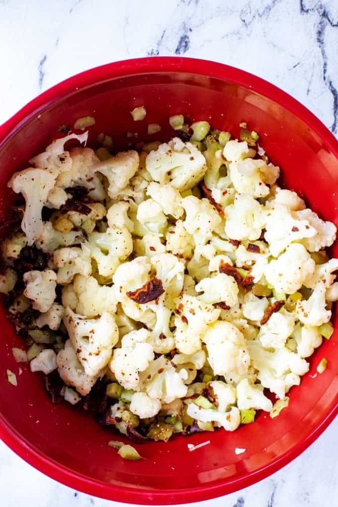 Photo of a large bowl of cauliflower, pickles, celery, and bacon.