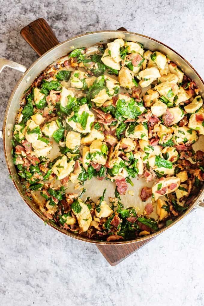 Photo of chicken, bacon, and spinach in a skillet.