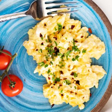 Overhead photo of a light blue plate with keto scrambled eggs.