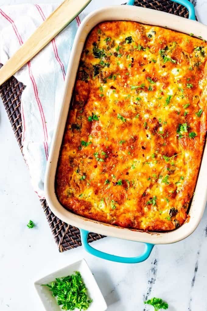 Overhead photo of a whole keto breakfast casserole with a serving spoon next to it.