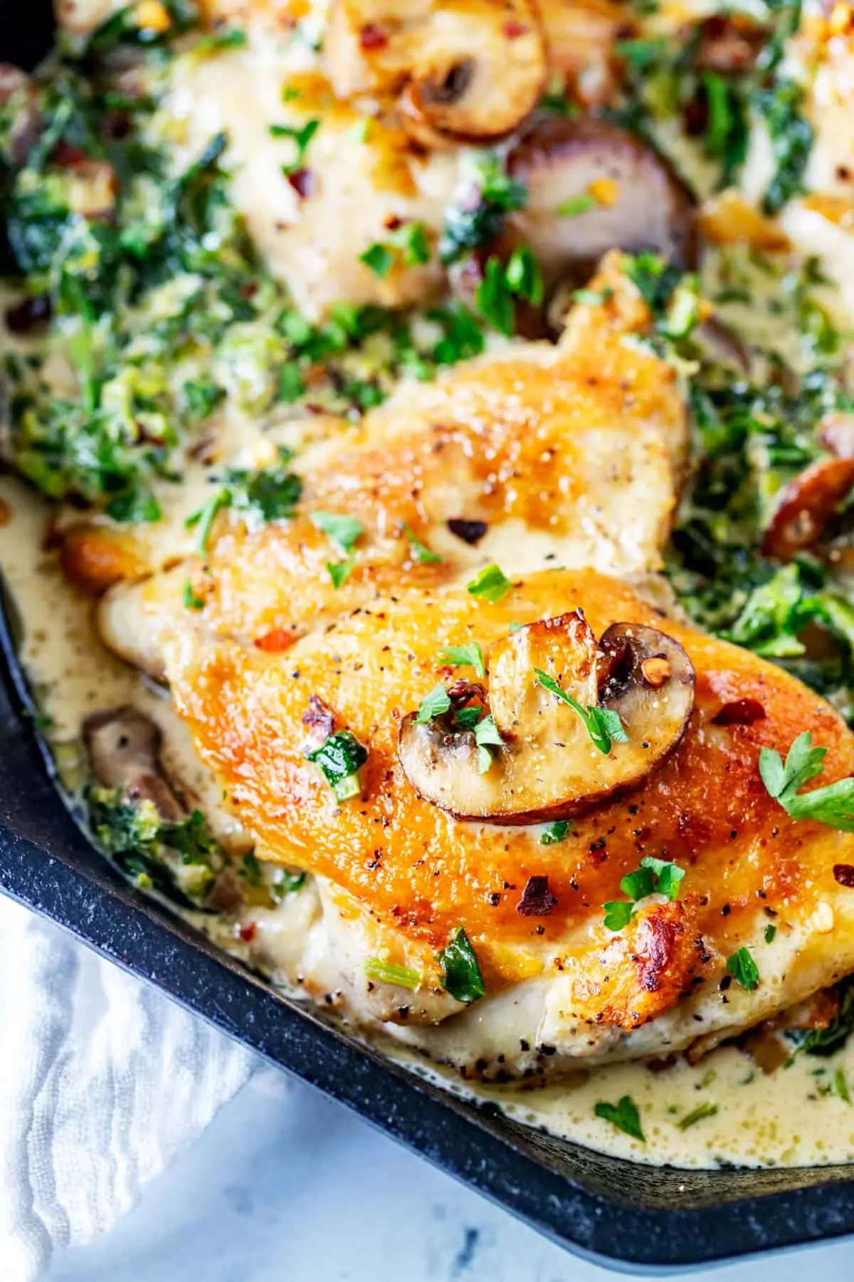 Close up photo of a cast iron skillet with keto creamy chicken in it.
