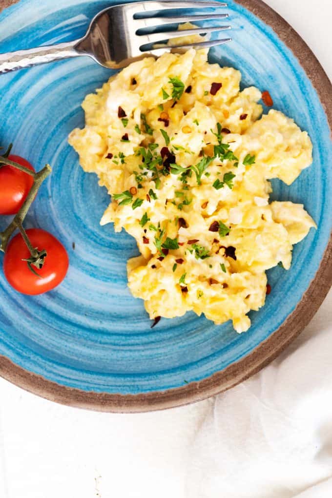 Overhead photo of a light blue plate with Keto Scrambled Eggs.