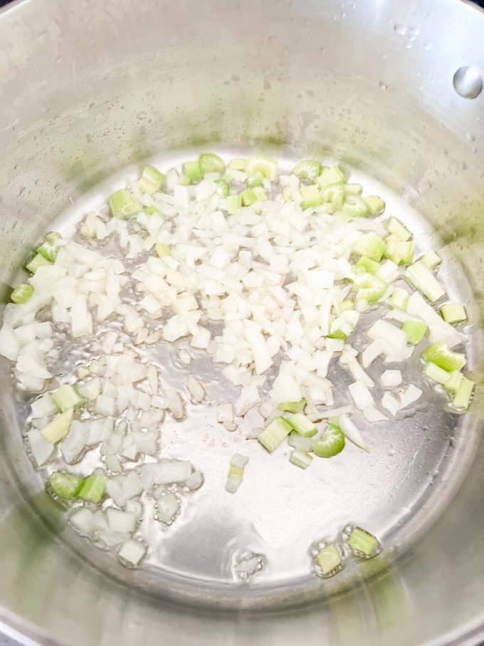 Onion and celery cooking in oil in a stockpot.