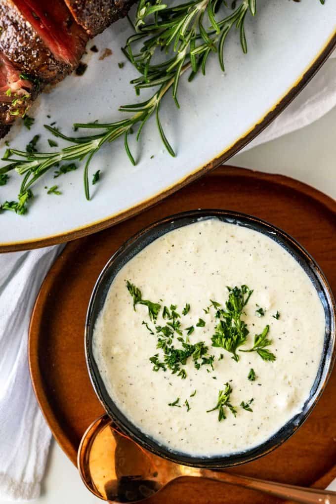 Overhead photo of a bowl of keto horseradish sauce garnished with parsley.