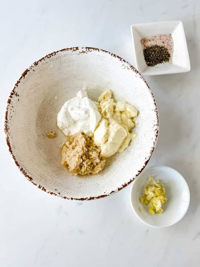 Photo of mayonnaise, sour cream, prepared horseradish, garlic, salt, and pepper in prep bowls.