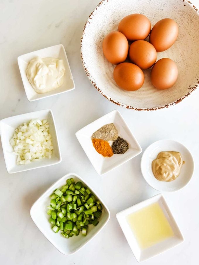 Photo of prep bowls with eggs, mayonnaise, onion, celery, seasonings, Dijon, and lemon juice.