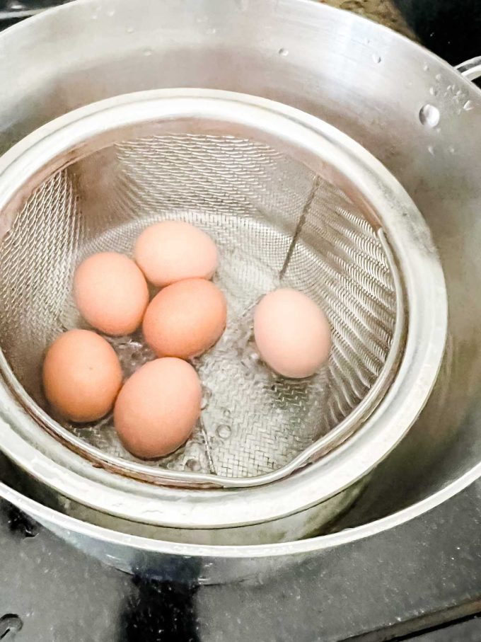 Photo of eggs cooking in a steamer basket.