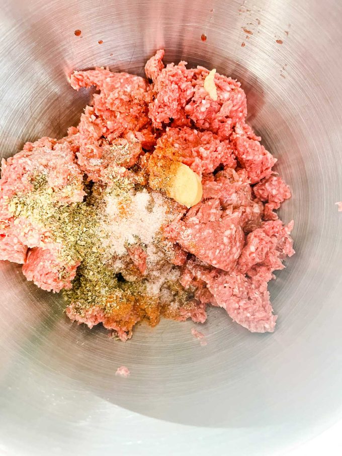 Photo of meat  and seasonings in a bowl.