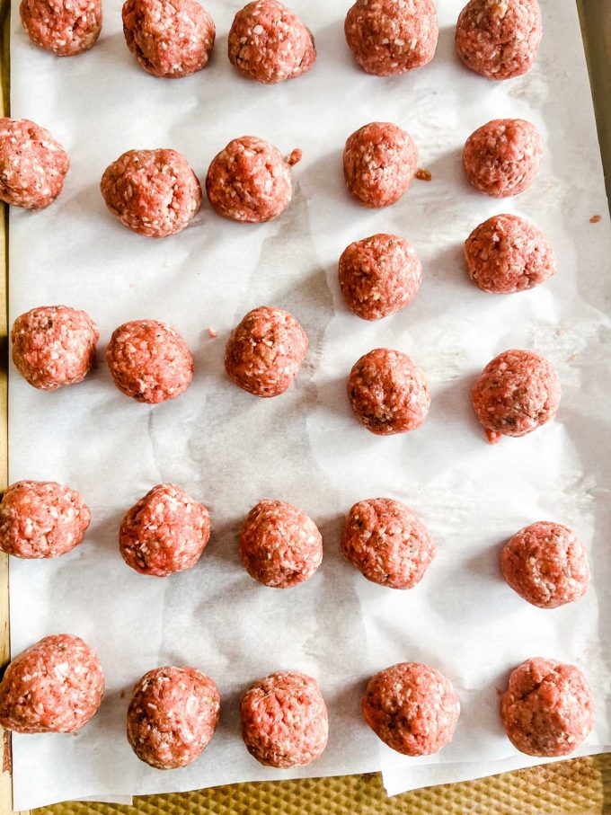 Photo of prepped meatballs on a baking sheet.