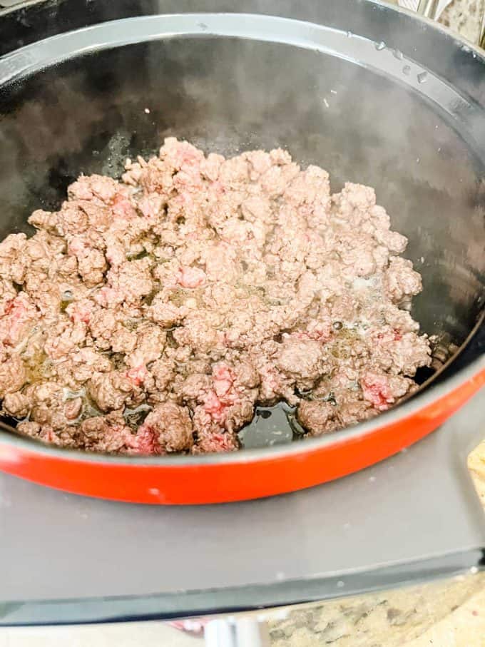 Photo of ground beef cooking in a dutch oven.