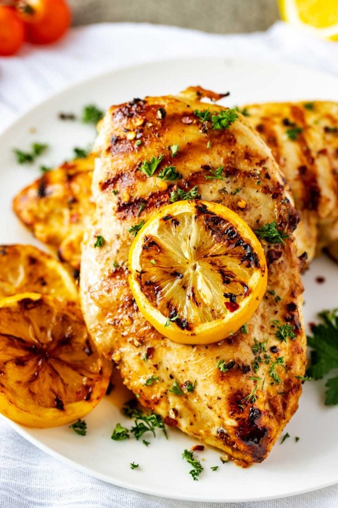 Close up photo of Grilled Lemon Pepper Chicken on a white plate.