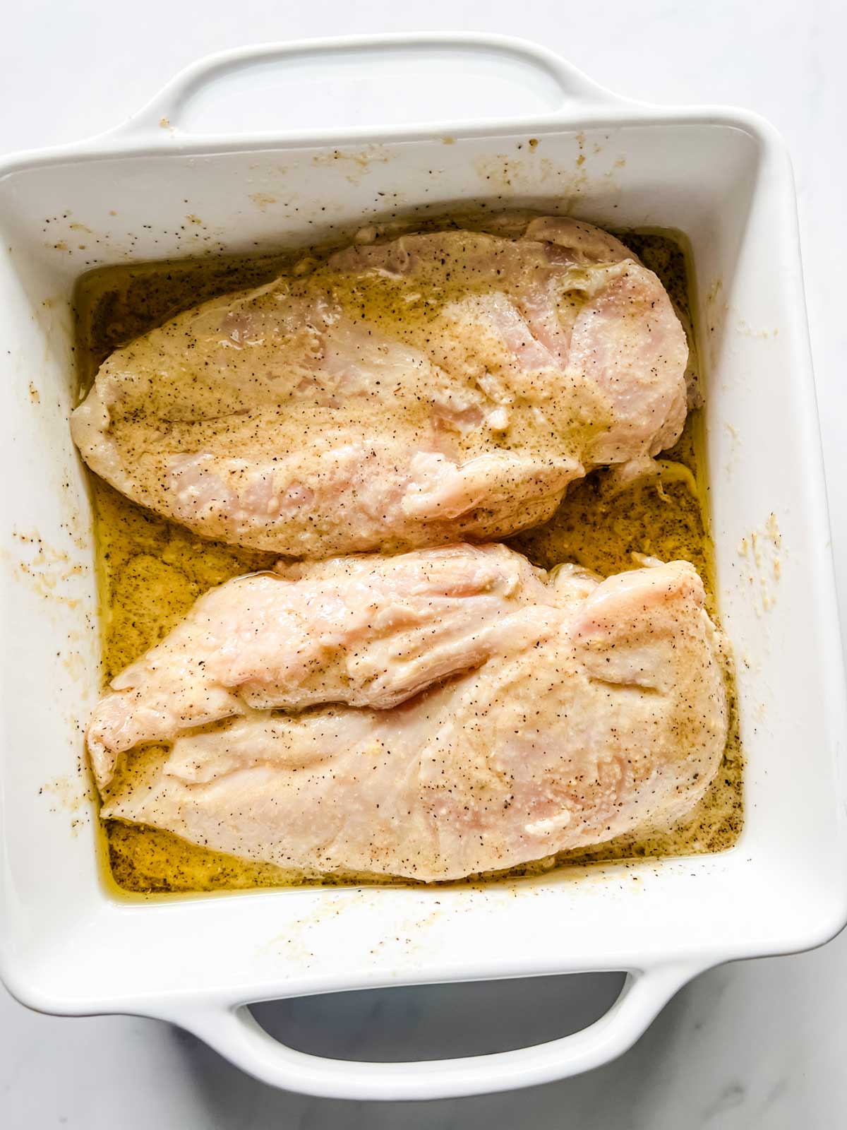 Chicken marinating in a shallow dish.