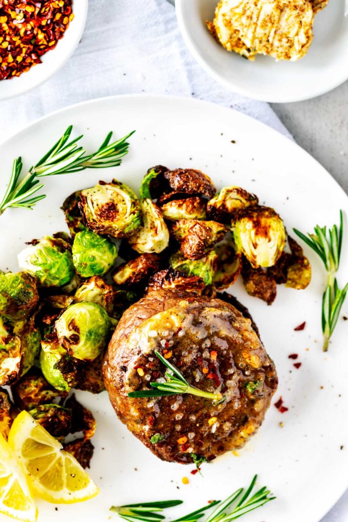 Air Fryer Filet plated with brussels sprouts, rosemary, and lemon.