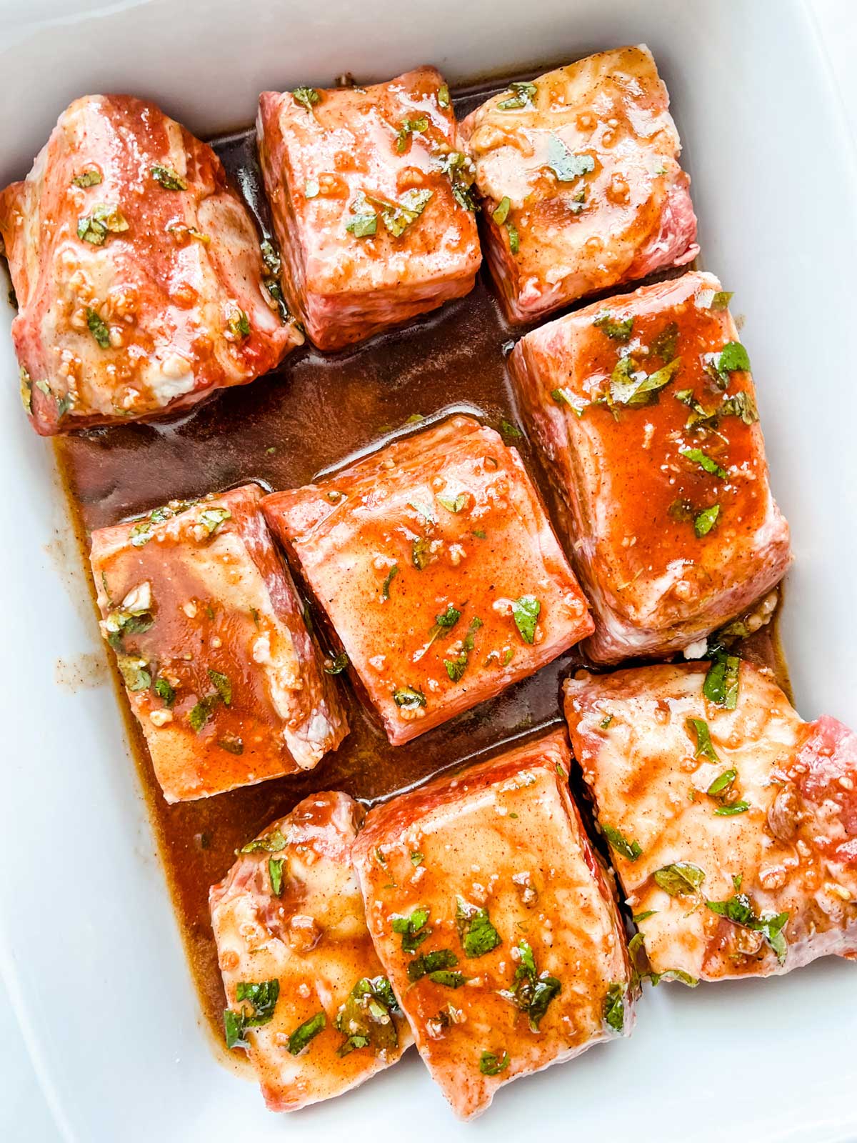 Photo of short ribs marinating in a casserole dish.