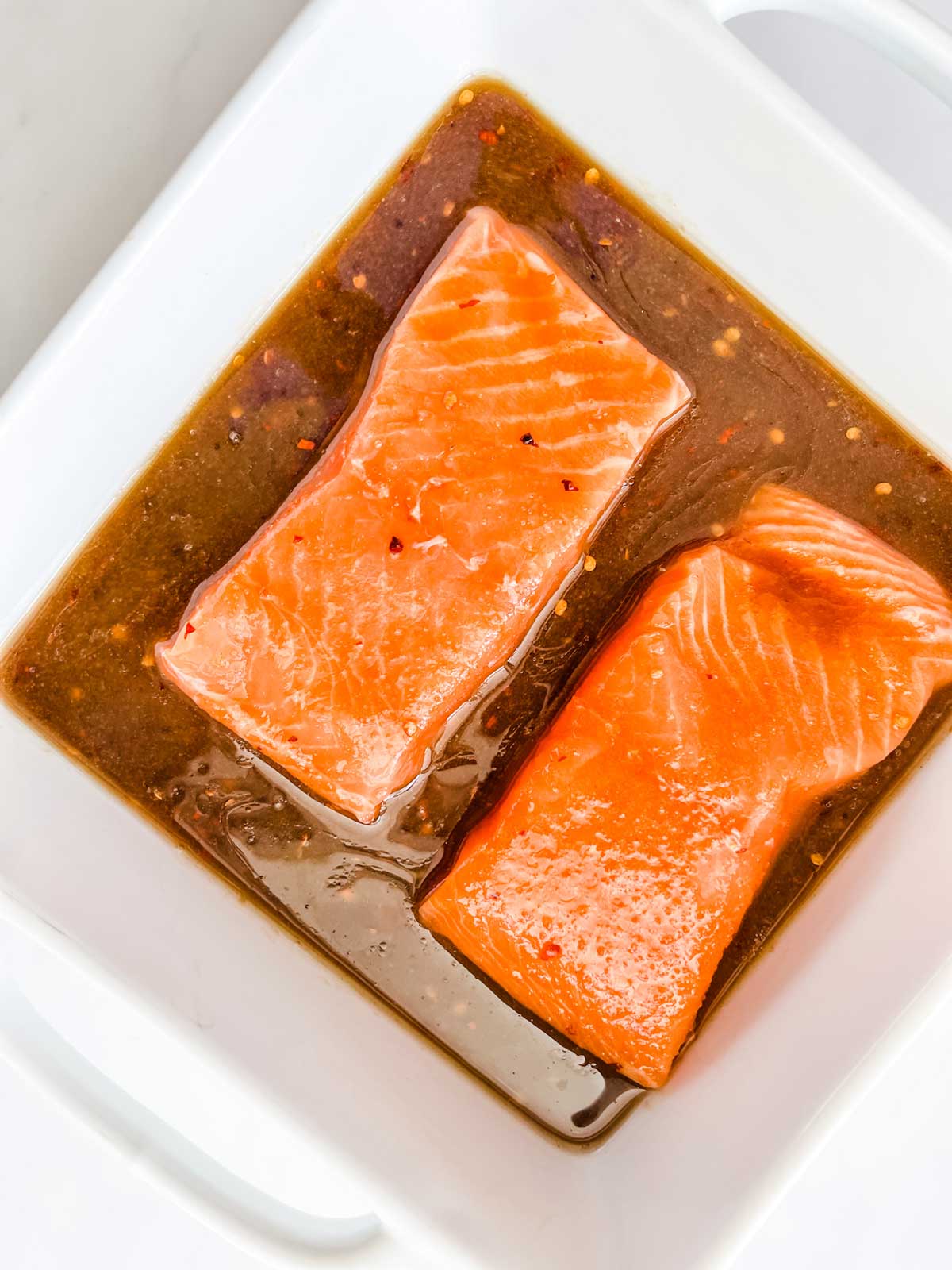 Salmon marinating in a shallow dish.