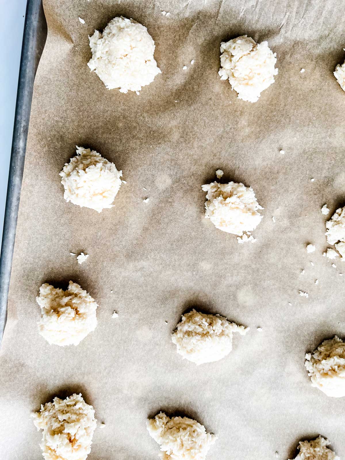 Photo of keto macaroons on a parchment lined baking sheet ready for the oven.