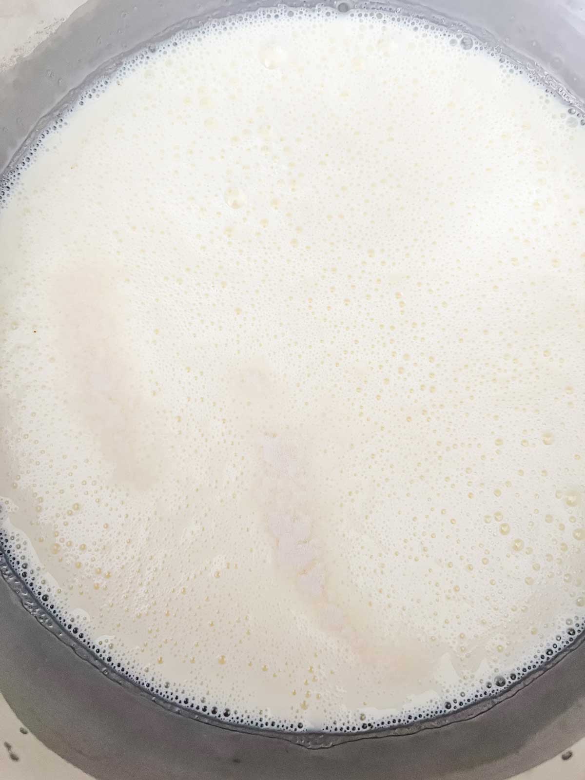 Cream and sweetener in a saucepan cooking.