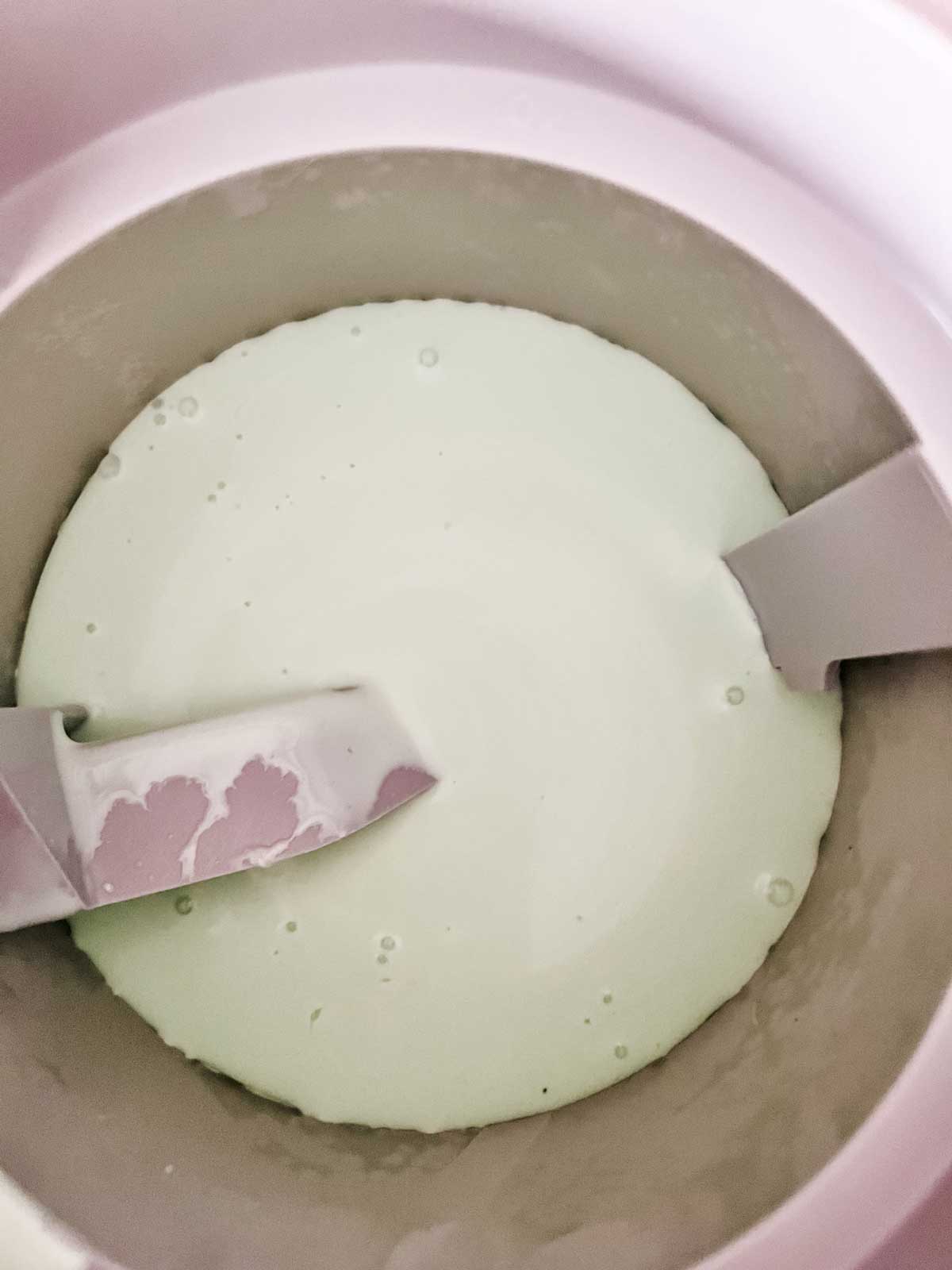 Keto mint chocolate chip ice cream in an ice cream maker ready to freeze.
