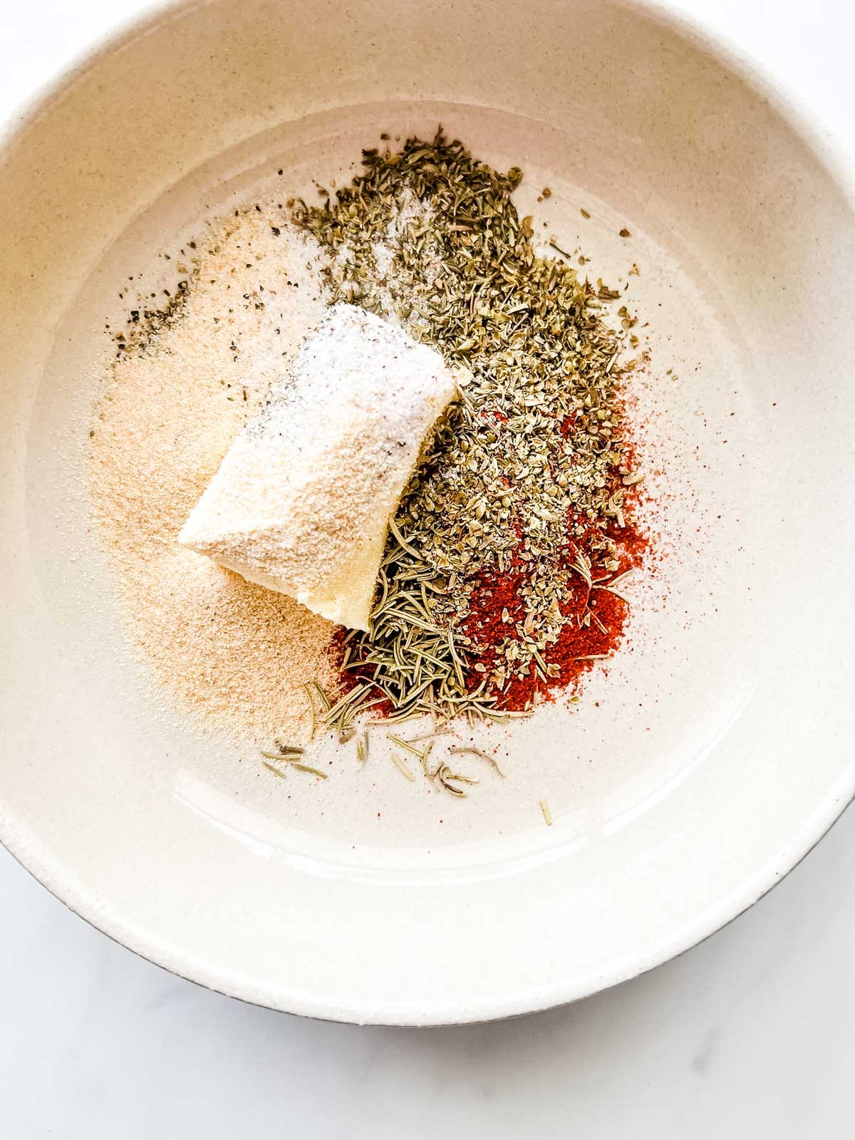 Photo of butter and seasonings in a small bowl.
