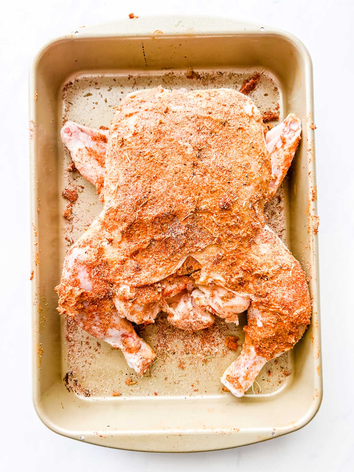 Photo of a seasoned air fryer chicken ready to be cooked.