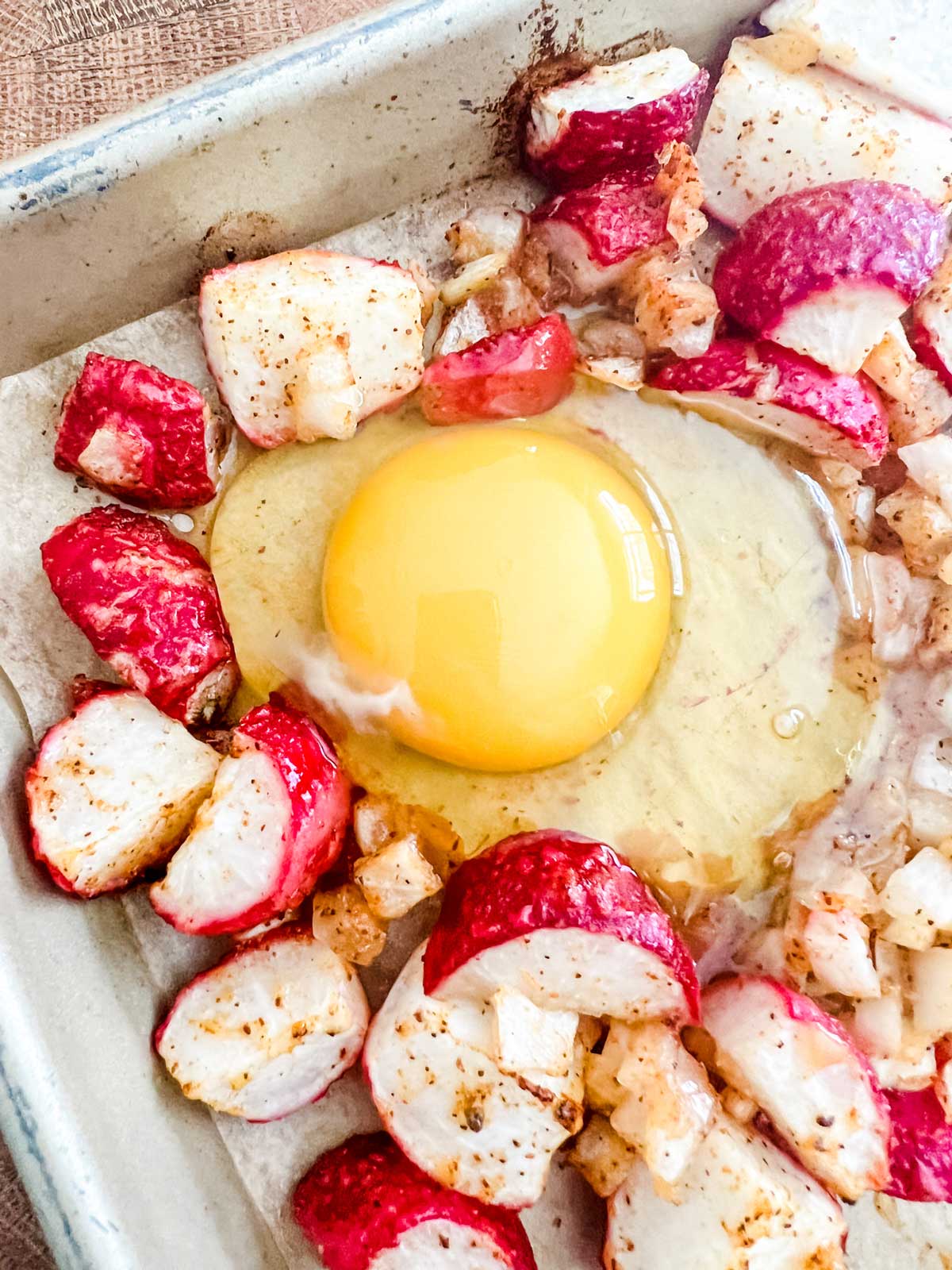 Sheet pan with radish, onion, and egg.