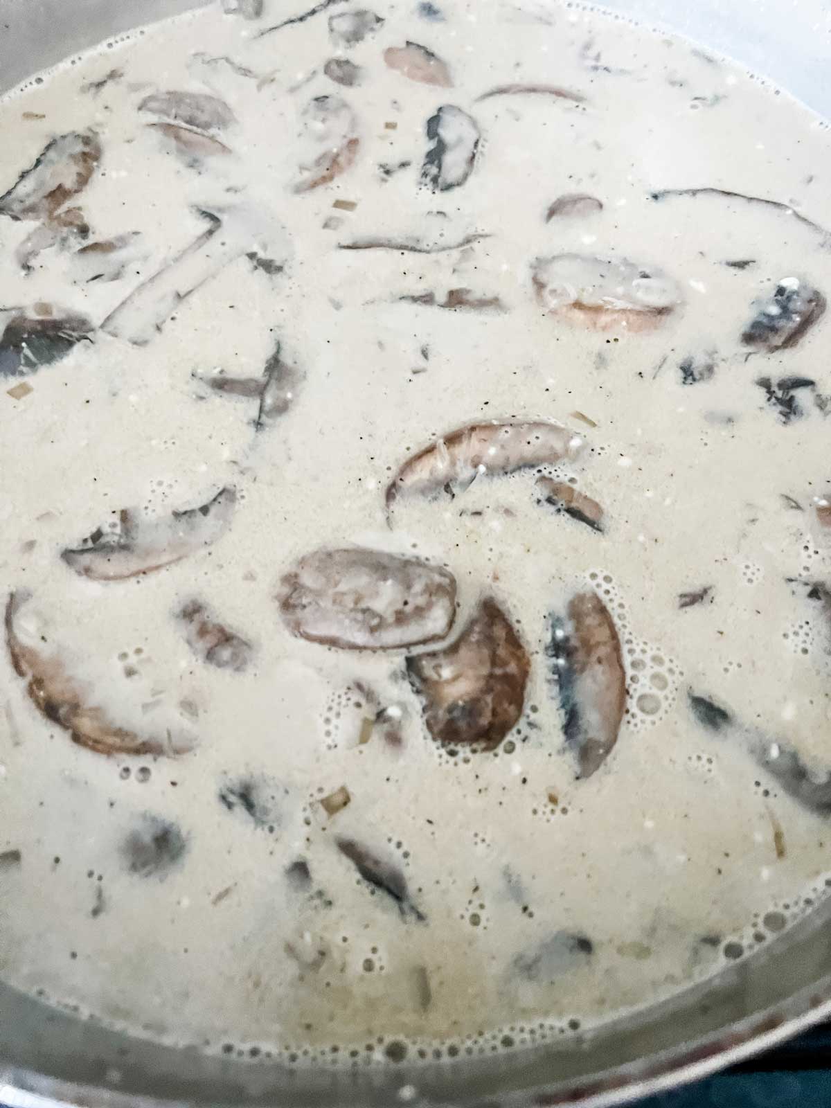 Photo of mushrooms in a skillet in a cream sauce.