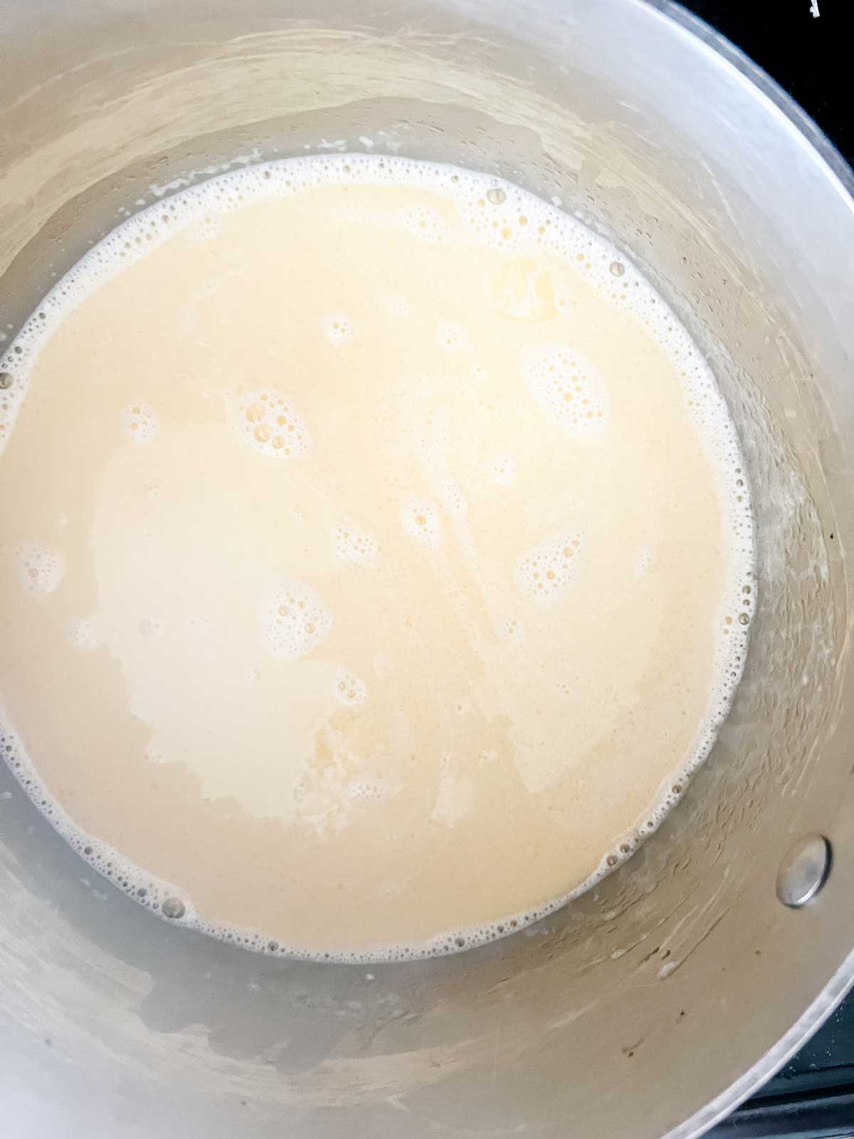 Photo of cream and butter mixed together in a saucepan.