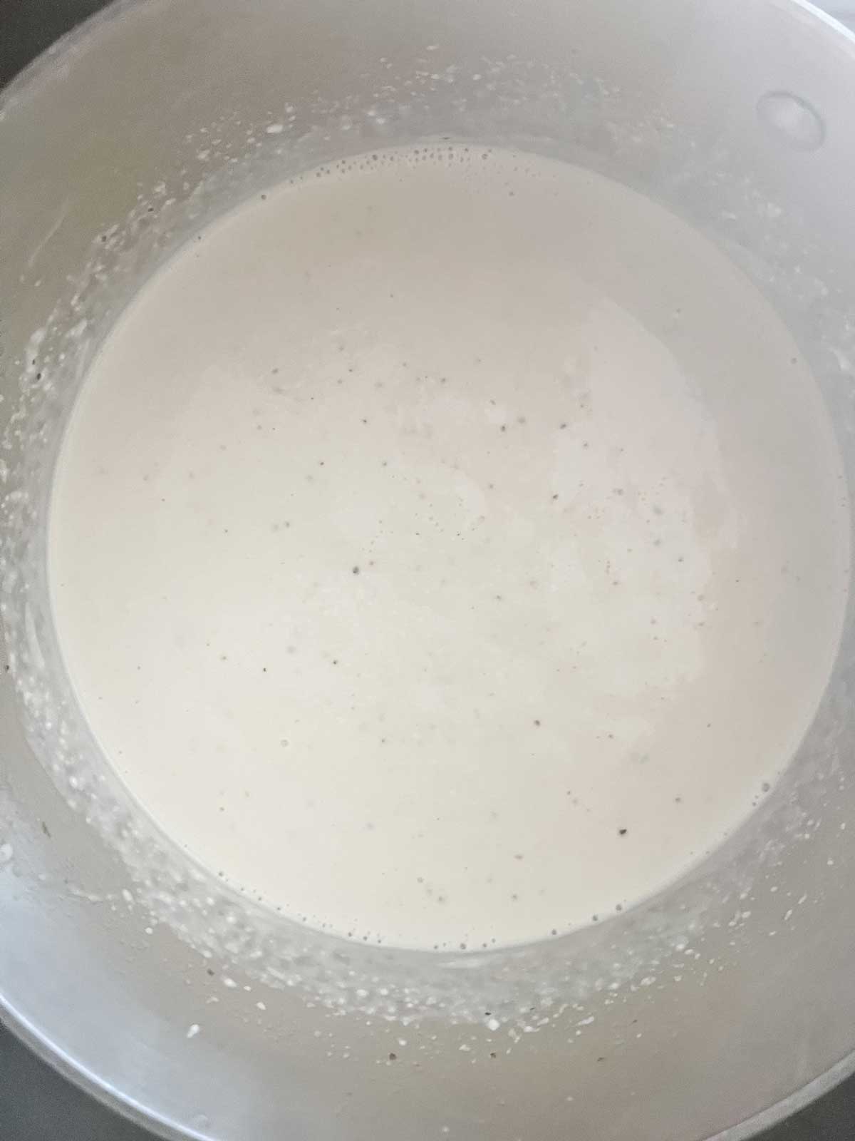 Photo of a cream sauce in a saucepan.