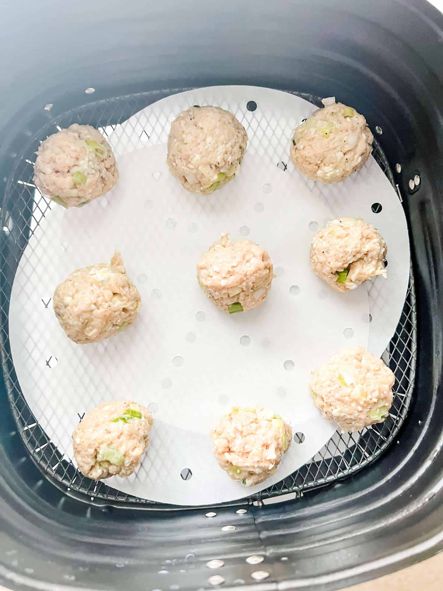 Chicken meatballs in an air fryer.