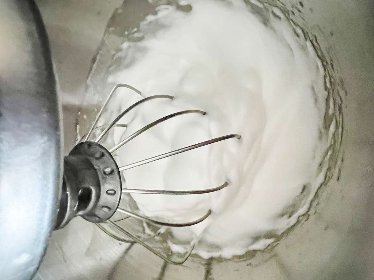 Horizontal image of egg whites being whipped in a blender.