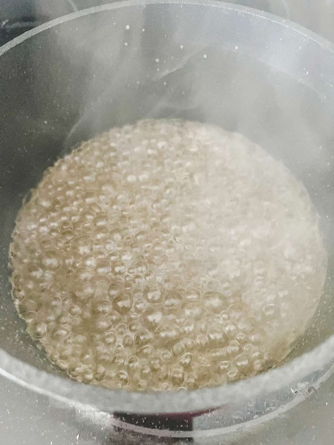Sweetener and water cooking in a saucepan.