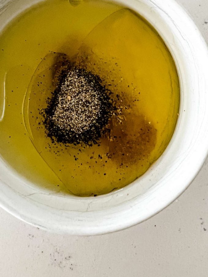 Photo of oil, lemon juice, and seasonings in a small dish.