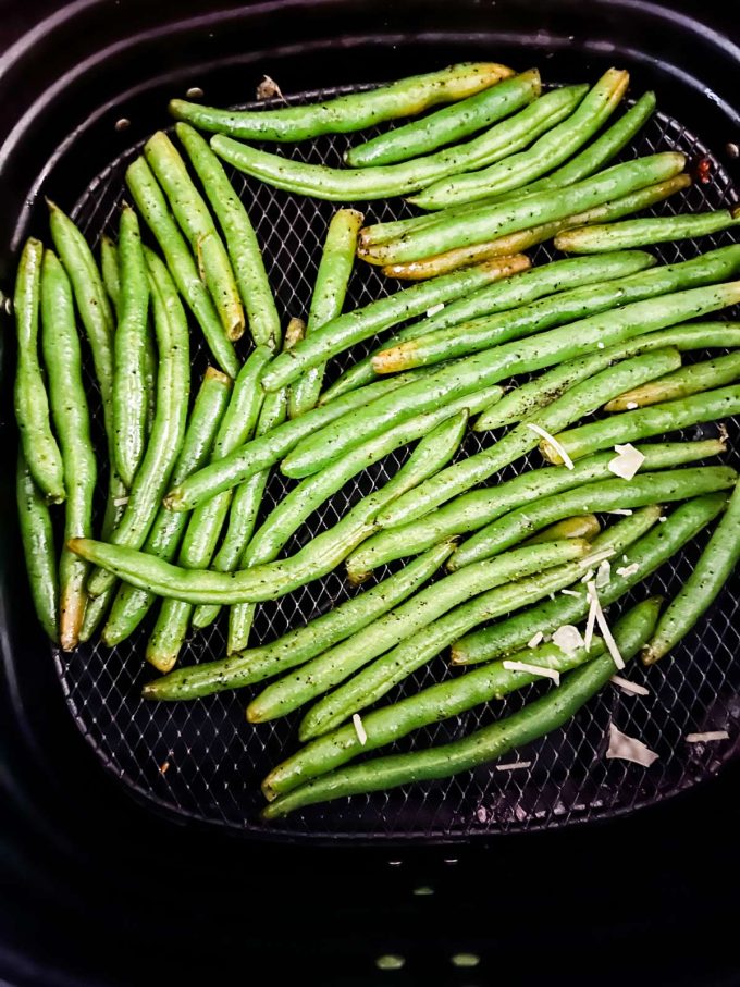Photo of green beans that have cooked in an air fryer basket.