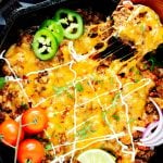 Overhead photo of a keto taco skillet with a cheesy serving being pulled from it.