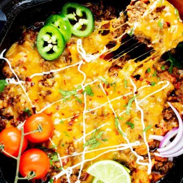 Overhead photo of a keto taco skillet with a cheesy spoonful being pulled from it.