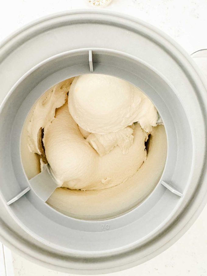 Vanilla ice cream in an ice cream maker that is ready for the freezer.