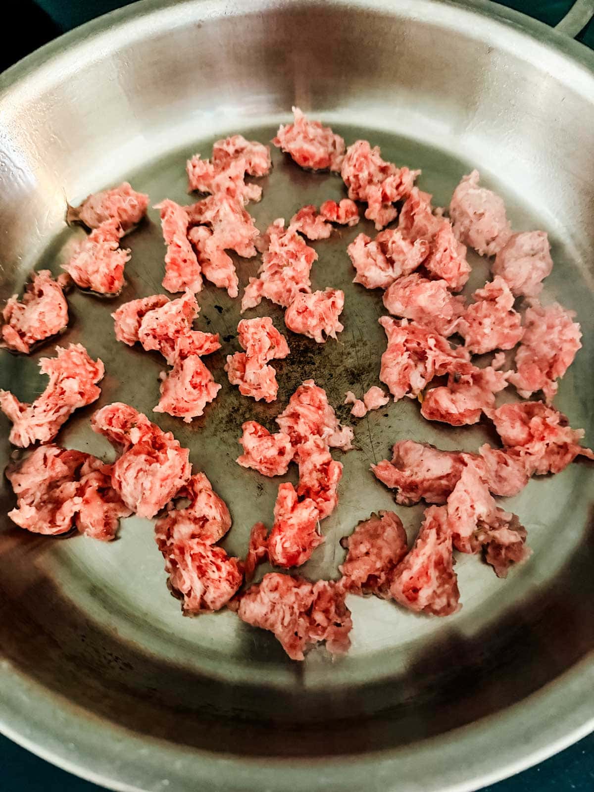 A bowl of sausage cooking in a skillet.
